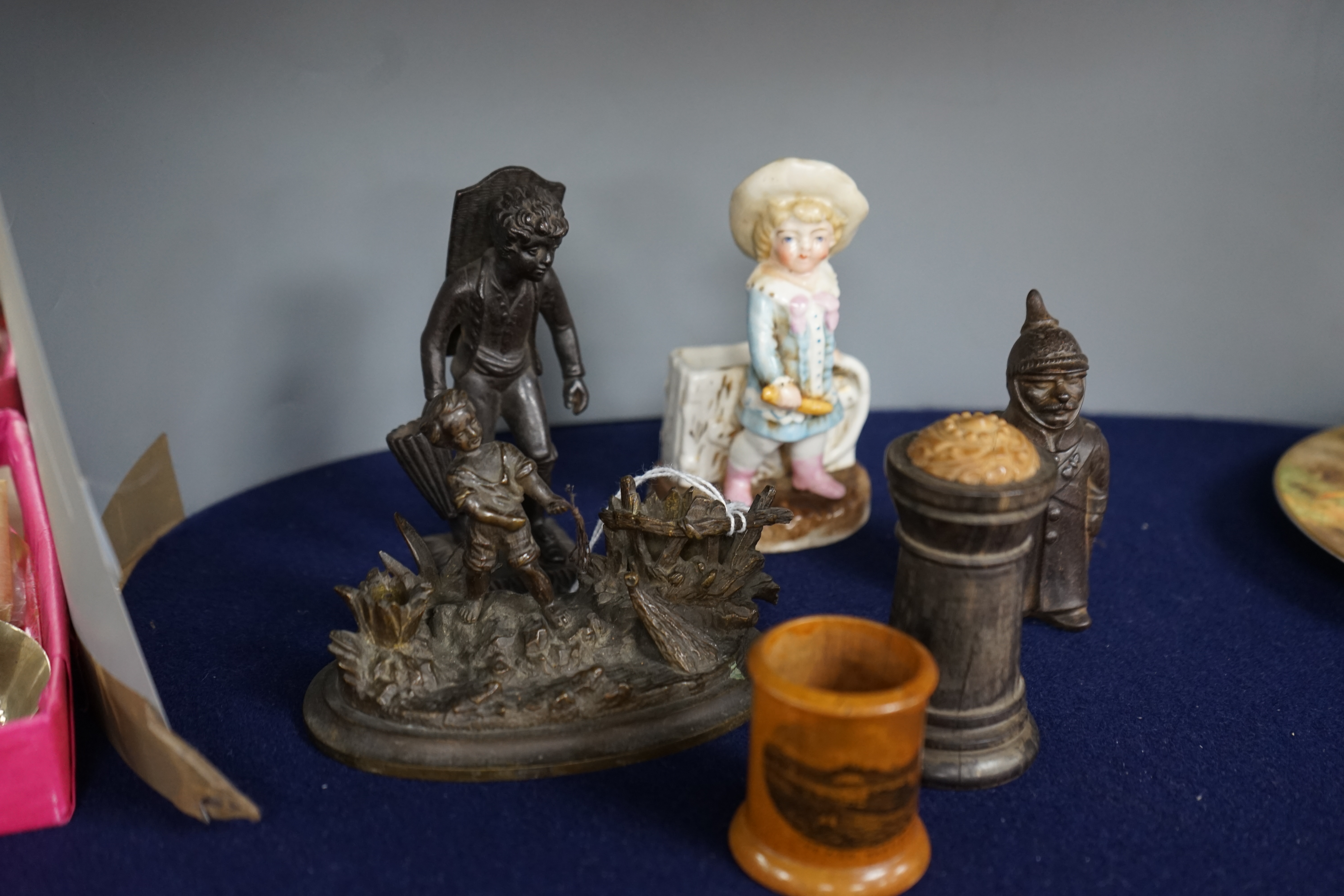 Six match tidies / strikers, including in the form of a WWI German soldier in trench coat and pickelhaube, a Mauchline ware pot with image of Hastings Pier, a cast metal figure of a boy, etc. Condition - fair